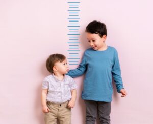 Twee kinderen staan bij een meetlat