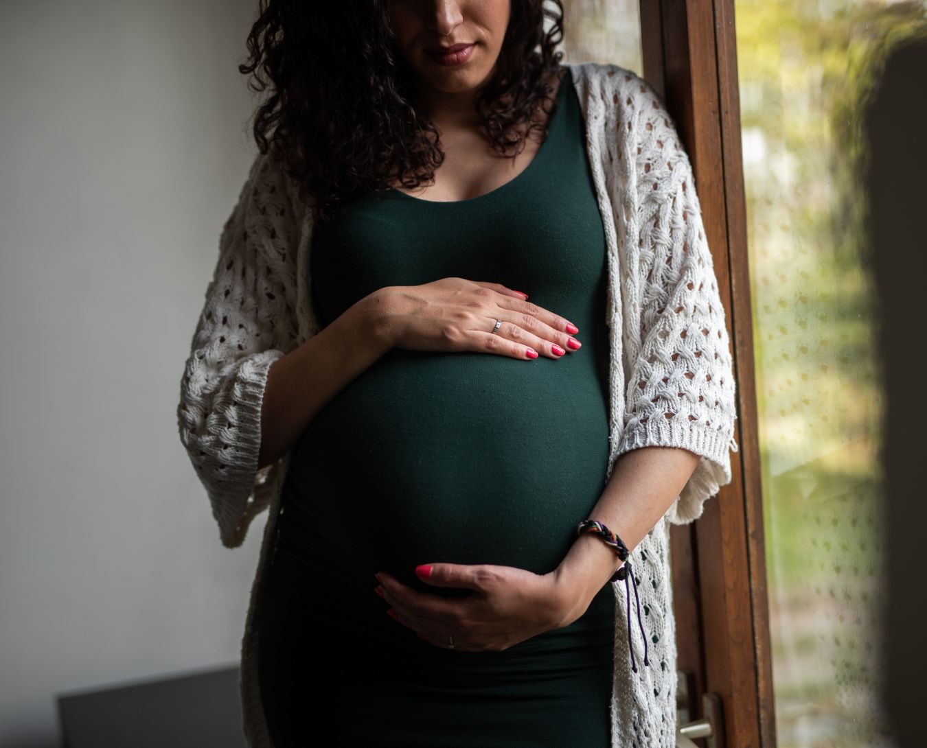 Een zwangere vrouw houdt haar handen om haar buik