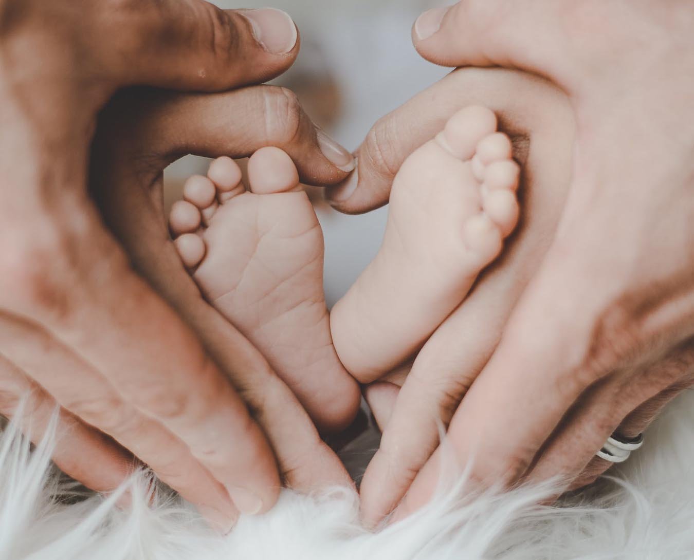 Babyvoetjes en de handen van vader en moeder