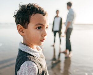 Een jongen op het strand met zijn ouders die ruzie maken