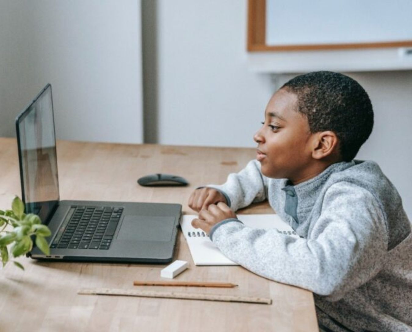 Een jongen kijkt naar zijn laptop