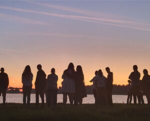 Groepjes mensen praten met elkaar bij zonsopgang